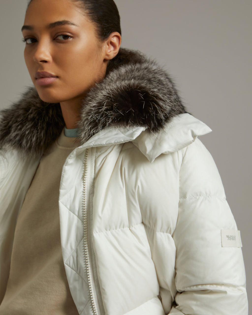 A line down jacket in water-repellent technical fabric with fox fur collar