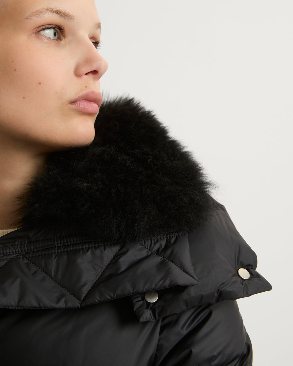 A line down jacket in water-repellent technical fabric with fluffy  lambswool collar