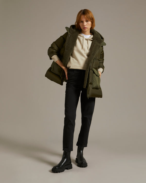 A line down jacket in a mix of technical fabrics with merino shearling hooded bib