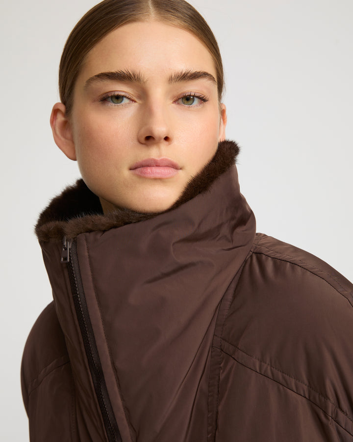 Technical fabric down cape with mink fur stand collar and lining.
